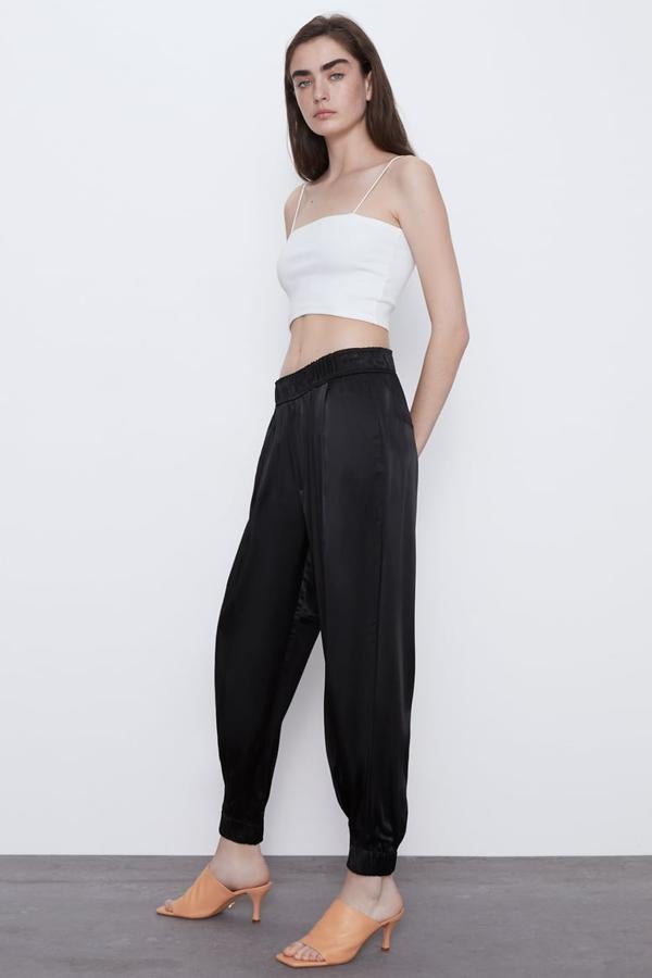 Zara nos propone este pantalón jogger de tiro alto y cintura elástica que le hemos visto lucir ya a muchas influencers. Con acabado satinado, dispone de bolsillos laterales y bajo acabado en puño. Cuesta 25,95 euros y lo tienes desde la talla XS hasta la XXL.
