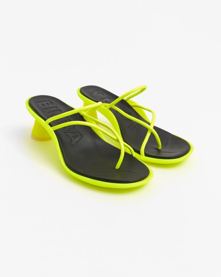 Este modelo de Bima y Lola que reinventa la tradicional sandalia de tiras nos ha llamado mucho la atención. Con goma, la suela y de piel en color amarillo flúor las tiras tubulares pretenden convertirse en las protagonistas de todas las miradas (135€).