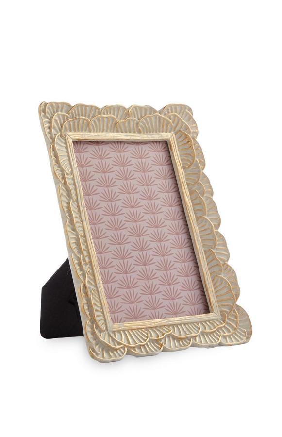 Tus fotos y recuerdos tienen que tener un sitio importante en tu casa. Como este marco de fotos dorado con formas de pétalos. Cuesta 4 euros.