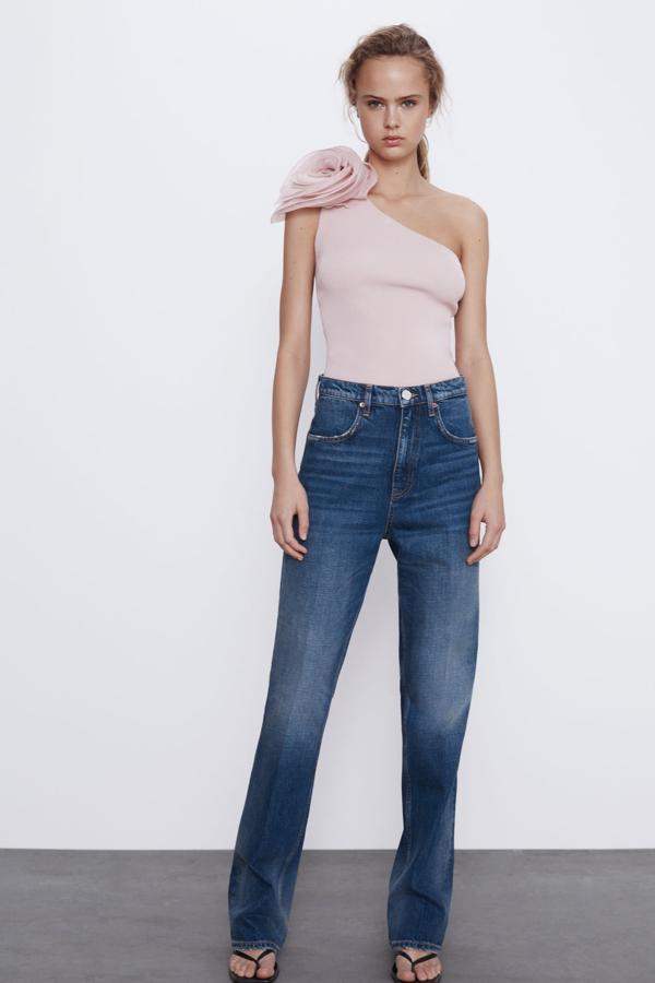 Para un estilismo informal o para un evento más arreglado, este top de punto con escote asimétrico de Zara no deja indiferente. Con un detalle de flor en organza del mismo color, en rosa palo, cuesta 19,95 euros y está disponible en las tallas S, M y L.