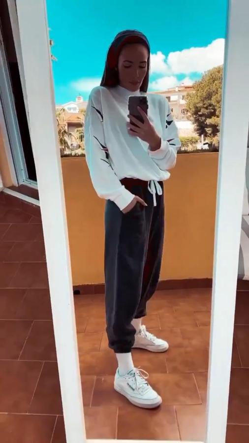 Sudadera blanca de Reebok a juego con las zapatillas de la misma marca y pantalón de chándal gris de Bershka.