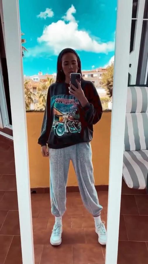 Suadera gris de corte oversize estampada que ha combinado con un básico gris de deporte. Ambas prendas son de Bershka.