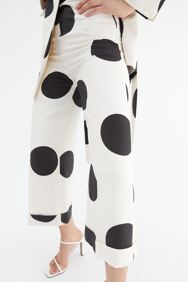 A medio camino entre el culotte y el cropped entallado está este pantalón blanco con maxi lunares a contraste en negro. Cuesta 29,99 euros y está disponible entre las tallas 36 y 42.