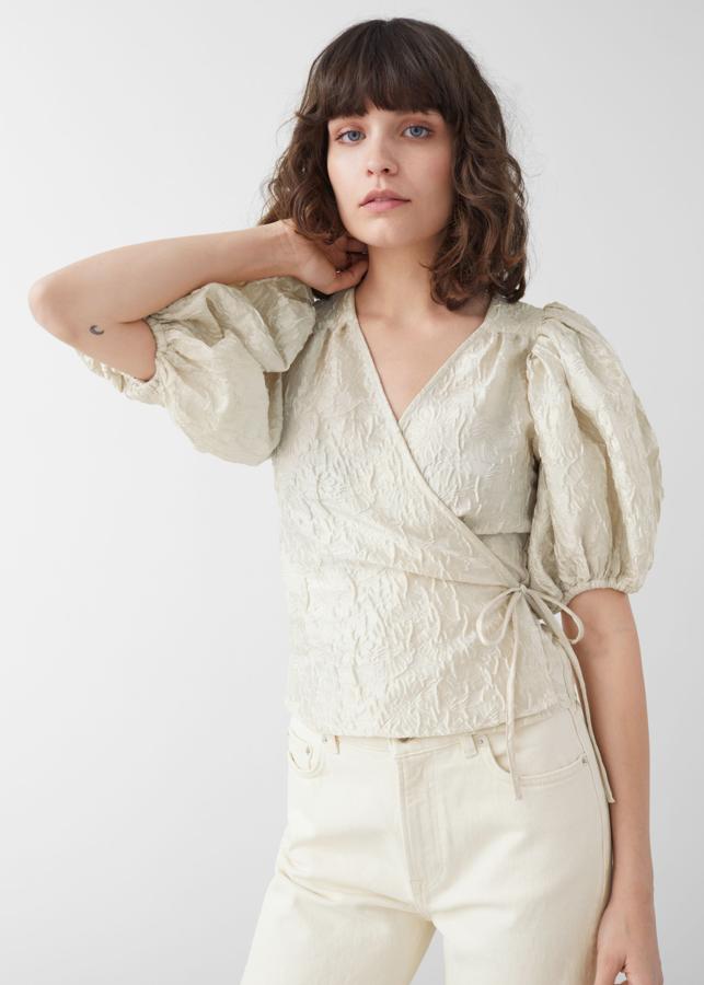 En tejido brocado, manga corta con mucho vuelo y cierre cruzado, nos encanta esta blusa diferente de & Other Stories (59 euros).