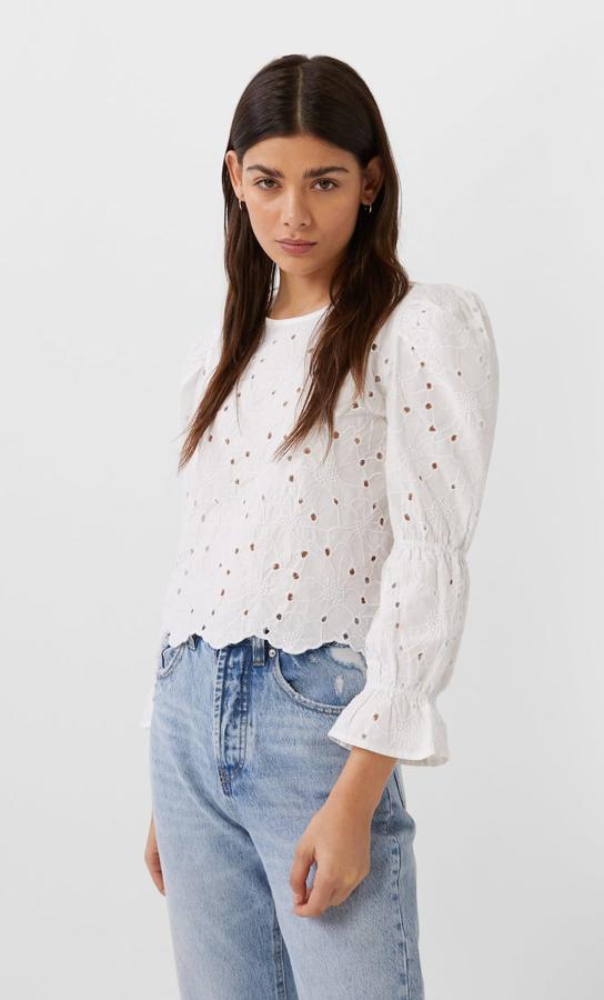 Blusa calada con flores y detalles de volante en las mangas, de Stradivarius (12,99 euros).
