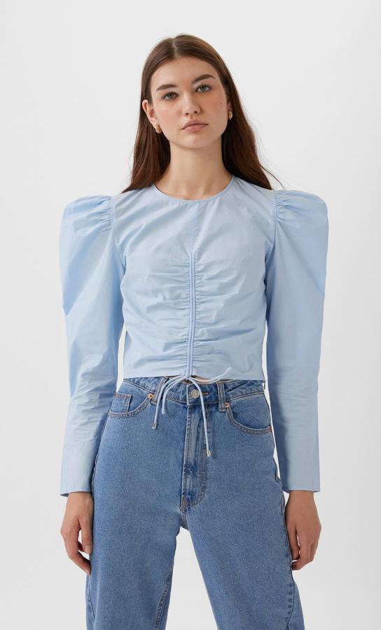 Stradivarius propone este modelo en tono azul bebé, con un lazo ajustable que hace un frunce a lo largo del cuerpo (17,99 euros).