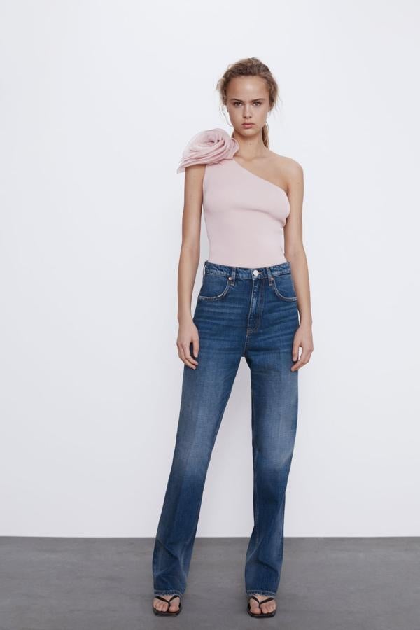 Con escote asimétrico y una flor de organza en el hombro, este top puede ser el recurso que necesitas para convertir una falda aburrida en un estilismo triunfador. Cuesta 19,95 euros y está disponible entre las tallas S y L.