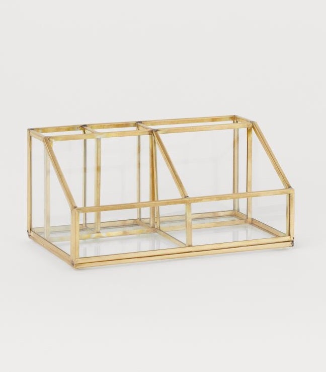 El diseño más elegante lo hemos encontrado en H&M con este organizador de maquillaje dorado con cinco compartimentos diferentes para brochas, lápices, máscaras de pestañas o labiales. (19,99 euros).