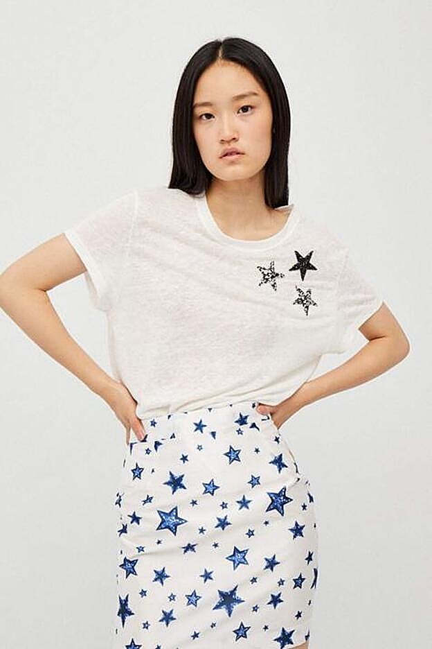 Camiseta con adorno de pedería en forma de estrellas y minifalda de Dolores Promesas.