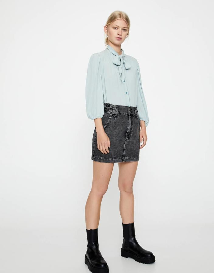 Este modelo de Pull & Bear está causando sensación. Con detalle de lazada al cuello y manga francesa, esta camisa en color verde agua (también tienes la opción en crudo) cuesta 17,99 euros y está disponible de la talla XS a la XL.