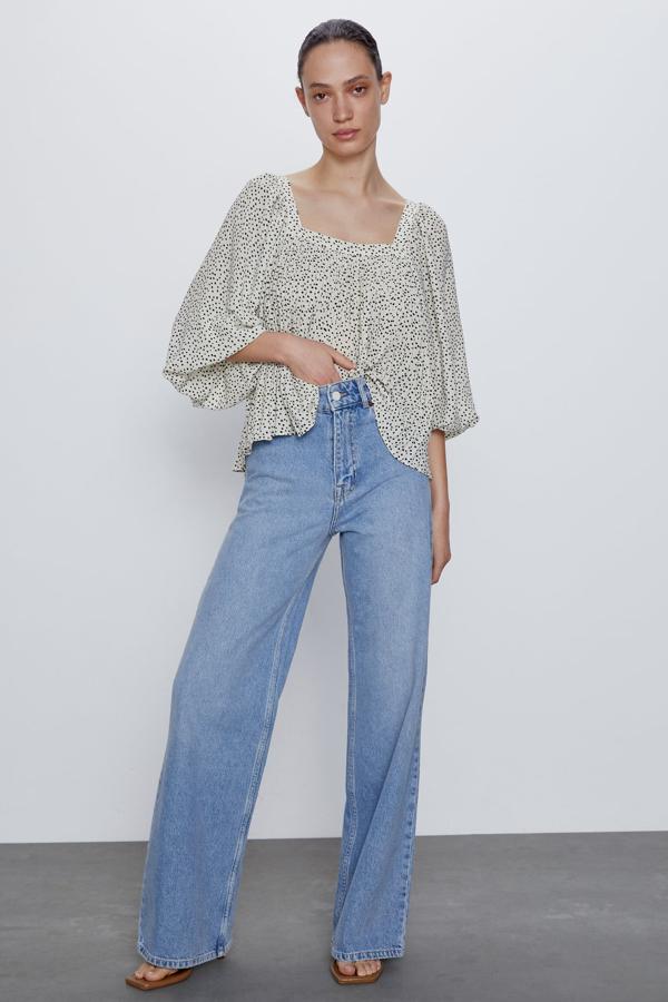 Esta camisa plisada con escote recto y manga abullonada por debajo del codo es de Zara. Tiene un estampado de pequeños topos en color negro, y está disponible desde la talla XS a la XL. Cuesta 25,95 euros.