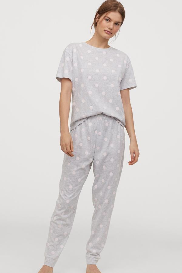 En color gris claro con lunares blancos (también disponible en color beige con corazones), este pijama de H&M está disponible desde la talla XS a la XL. Está formado por camiseta de manga corta con cuello redondo y pantalón a juego con elástico en el bajo. Tiene un precio de 19,99 euros.