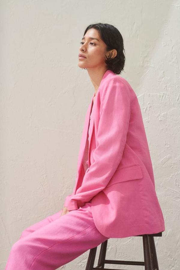 Color rosa chicle para esta americana de H&M en mezcla de lino y viscosa, con solapas de muesca y bolsillos delanteros ribeteados. Cuesta 29,99 euros y está disponible entre las tallas 42 y 50.