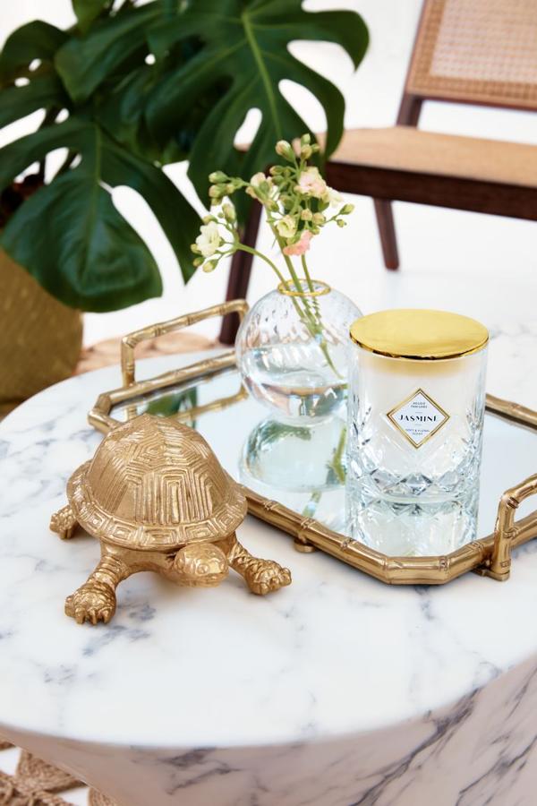 Decorar los rincones de tu salón es un 'must'. Caja en forma de tortuga, (17,99 euros). Vela, (17,99 euros). Bandeja dorada, (29,99 euros).