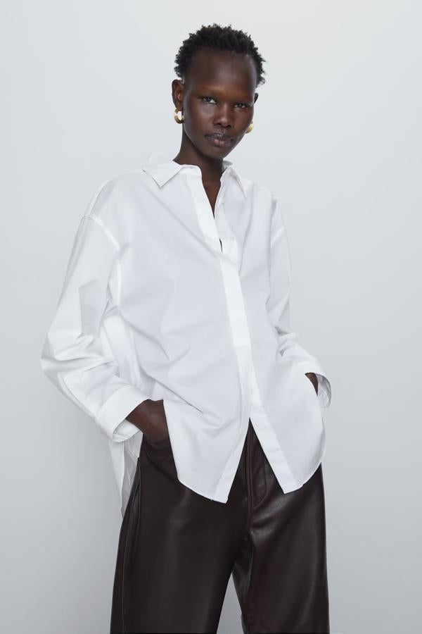 La camisa blanca de toda la vida, pero en versión oversize. También la puedes llevar en verano con unos shorts vaqueros, un look perfecto. Esta es de Zara (29,95 euros).