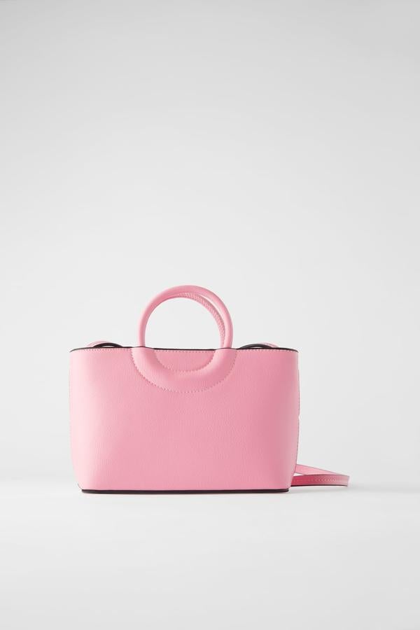 Disponible en rosa y en negro, este bolso formato mini city tiene el cuerpo con pespuntes en contraste de color y unas bonitas asas de mano redondas, además del asa de hombro ajustable. De Zara, costaba 19,95 euros y ahora 9,99.