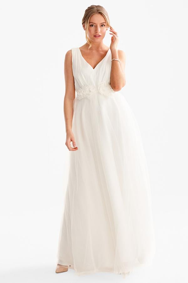 Vestido de novia con parte de arriba drapeada, fluida falda de tul y flores brillantes en la cintura (179,90 euros).