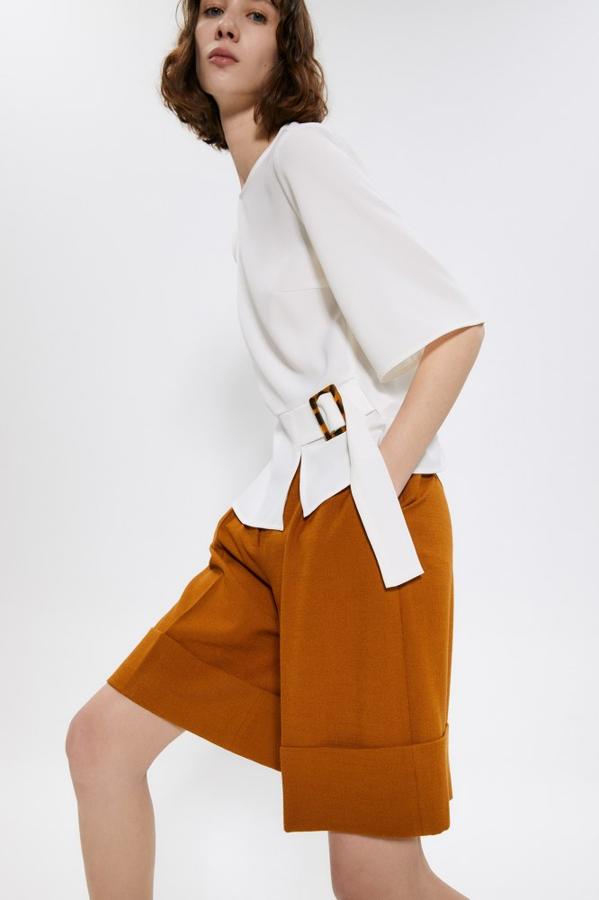 Otra de nuestras favoritas es esta blusa de Sfera con cuello caja y detalle de hebilla con lazada en carey. Cuesta 17,99 euros y está disponible en las tallas S y M.