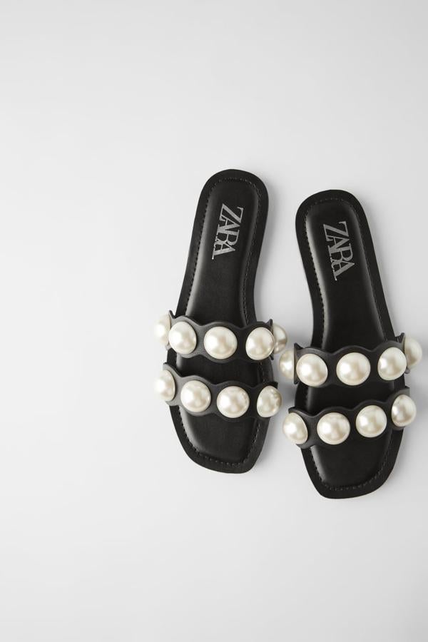 Diez perlas divididas en dos tiras onduladas para estas sandalias planas en color negro de Zara. Con la planta acolchada, cuestan 29,95 euros y está disponible entre los números 35 y 42.