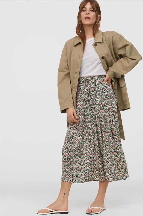 Con pliegues en la parte superior para dar amplitud, esta falda con elástico fruncido detrás y botones decorativos en la parte frontal, esta falda de poliéster de H&M con estampado de miniflores cuesta 24,99 euros. Está disponible entre las tallas 32 y 50.