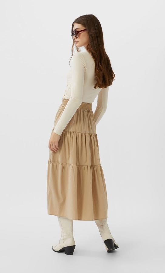 En Stradivarius hemos encontrado esta propuesta en color salmón con cintura elástica en popelín y diseño de volantes. Cuesta 19,99 euros y está disponible entre las tallas XS y XL. También podemos comprarla en negro.