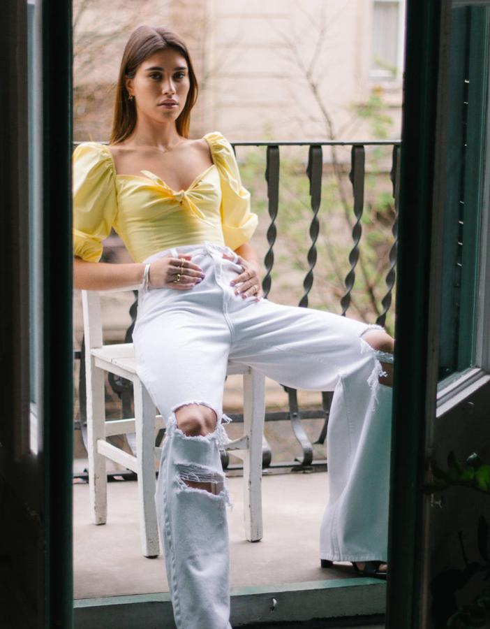 Si el minimalismo no es lo tuyo, te proponemos este top estilo mesonera, con las mangas 'puffy' de moda y un escote corazón rematado en un lazo. Reúne tanta tendencia que cualquier prenda que lo acompañe quedará automáticamente actualizada (Bershka, 19,99 euros). Y es amarillo: punto extra.