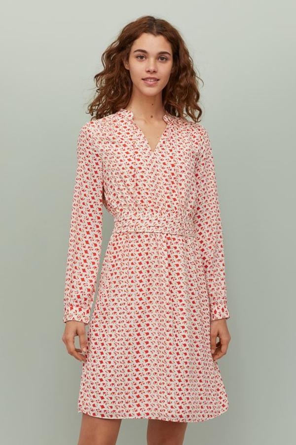 Una de nuestras propuestas favoritas es este vestido de H&M con cuello elevado corto y escote de pico con tiras de anudar. Entallado, con manga larga y fruncidos en los hombros, está forrado y tiene un precio de 29,99 euros. Está disponible entre las tallas 32 y 50.