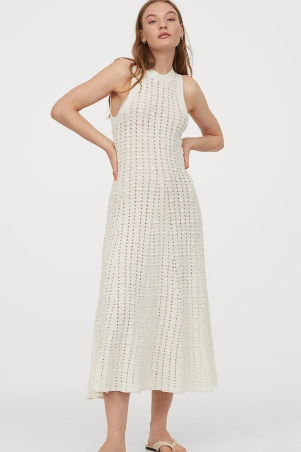 H&M nos propone este vestido largo en punto calado de mezcla de algodón con caída. En color blanco y ribete de canalé en cuello y axilas, tiene un precio de 59,99 euros. Está disponible desde la talla XS a la XL.
