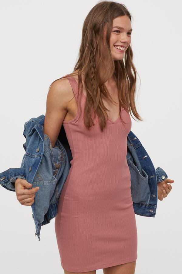 En color rosa (aunque también lo puedes encontrar en negro), este vestido mini entallado en punto de canalé y escote de pico realzará tu figura. Tiene un precio de 9,99 euros, es de H&M y está disponible desde la talla XXS a la XL.