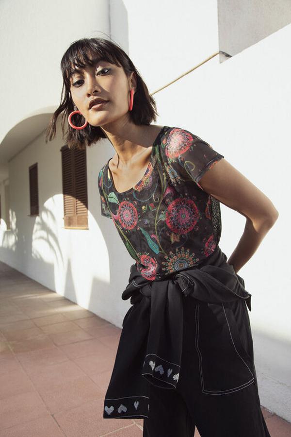 Escote redondo y un algodón extra ligero. Somos muy fans de esta camiseta con fondo negro y mandalas de colores que te quedará ideal con unos vaqueros para el día o con una falda de raso negra para las noches de verano.  Su precio es de 39,95 euros.