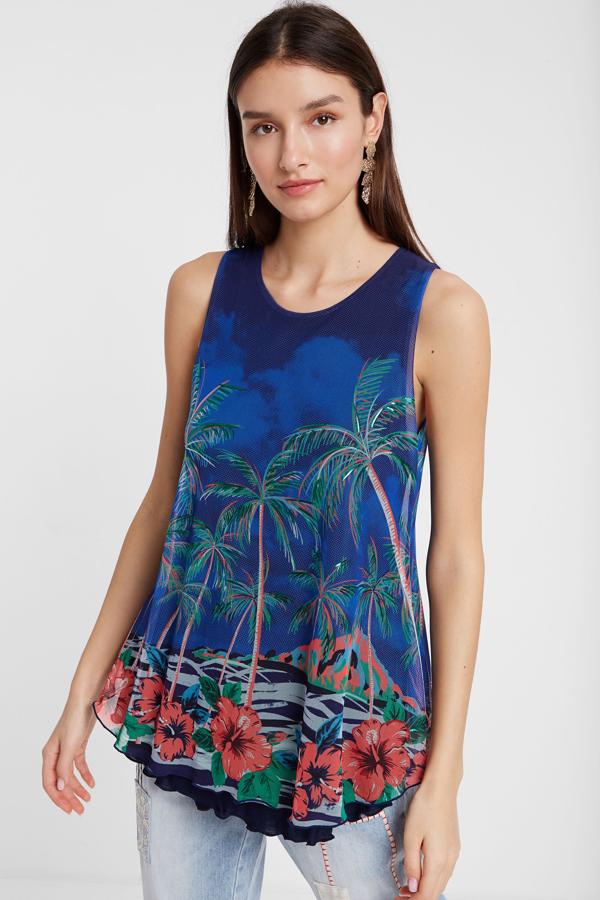 Es ver esta camiseta y transportarnos, directamente, a una playa paradisíaca. Su estampado de flores y palmeras es irresistible, pero también su patrón con doble capa y vuelo en el bajo.  Su precio es de 49,95 euros.