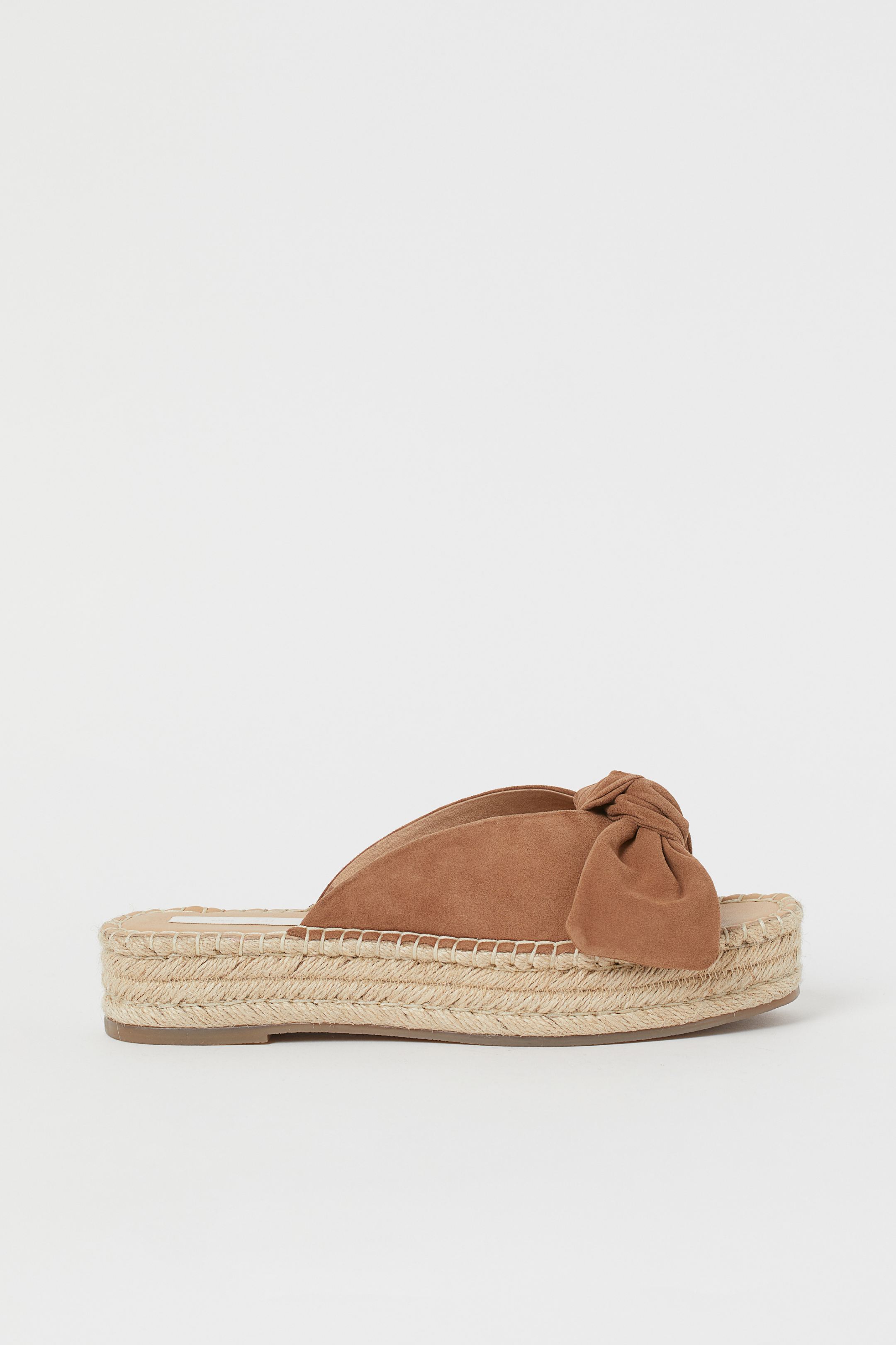 El ante se cuela en estas sandalias de la nueva colección de H&M con diseño de lazo en tono marrón calor. (34,99 euros).