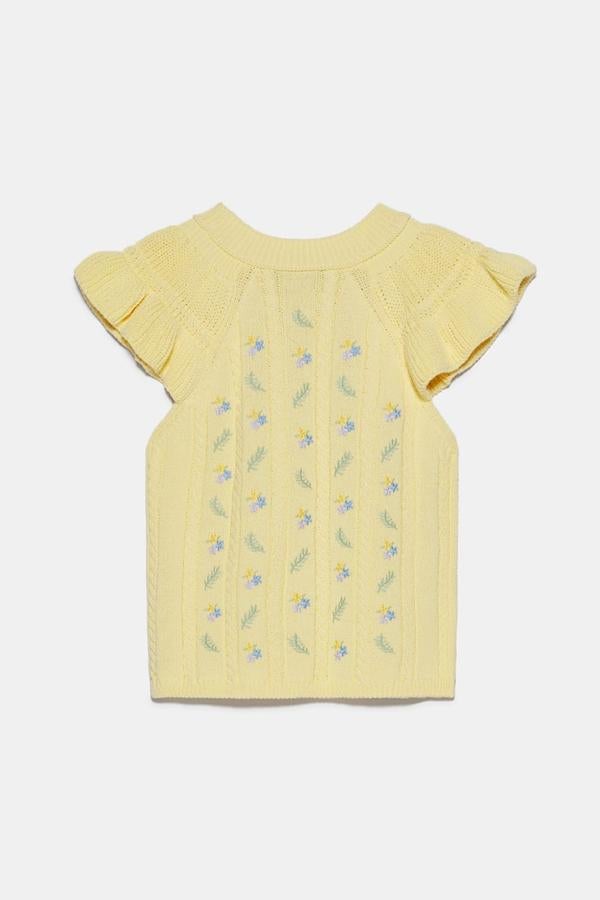 Como si estuviera hecho a mando, así es este top que también hace las veces de chaleco, en color amarillo, con volantes en las mangas (19,95 euros).
