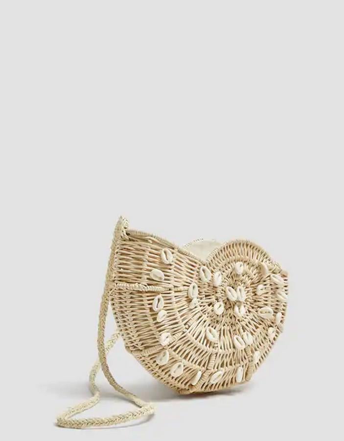 Otro de nuestros favoritos es este bolso bandolera de cestería con forma de caracola y detalle de caracolas en el frontal. Tiene una bolsa de tela en su interior que se cierra con cuerda corrediza. Tiene un precio de 35,99 euros.