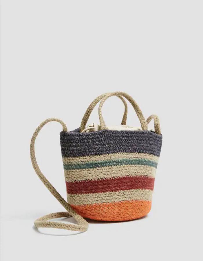 Con detalle de asa corta y larga, y bolsa de tela interior, este bolso mini tipo capazo está confeccionado en yute y cuesta 22,99 euros.