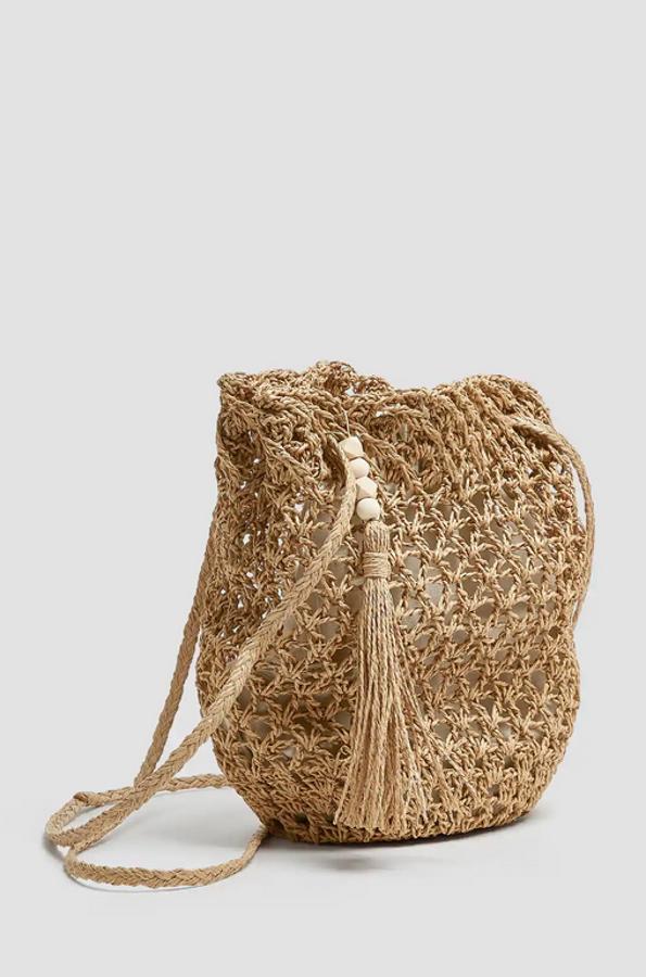 Todas las tendencias en uno para este bolso tipo saca que gracias a su asa larga se convierte en bandolera. Con detalle de borla y bolsa de tela interior, cuesta 17,99 euros.