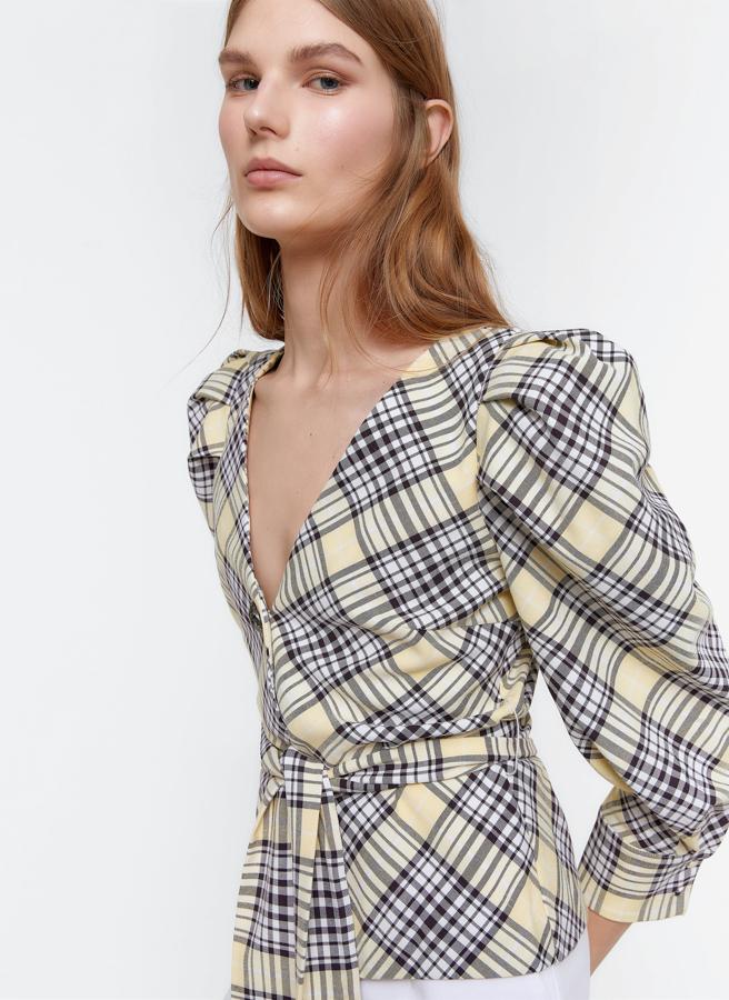 Blusa de cuadros con botonadura delantera, manga abullonada y cinturón de la misma tela, de los Special Prices de Uterqüe (55,30 euros).