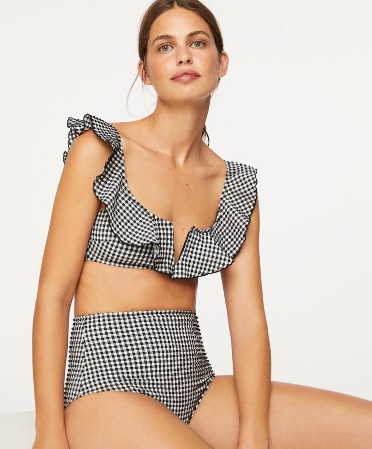 Este bikini con estampado de cuadros vichy en color negro es de Oysho. Está formado por un favorecedor sujetador (19,99 euros) con escote en forma de V y detalle de volantes, y una braguita (15,99 euros) de cintura alta.