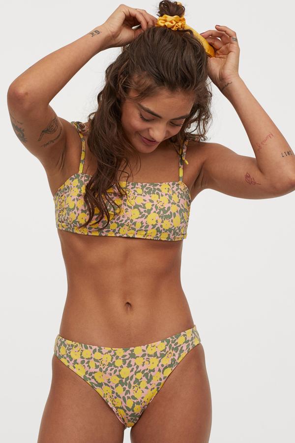 Este bikini floral de H&M en rosa y amarillo está formado por un top (14,99 euros) bandeau con relleno extraíble y tirantes anudados al hombro, y braguita (9,99 euros) de talle bajo.