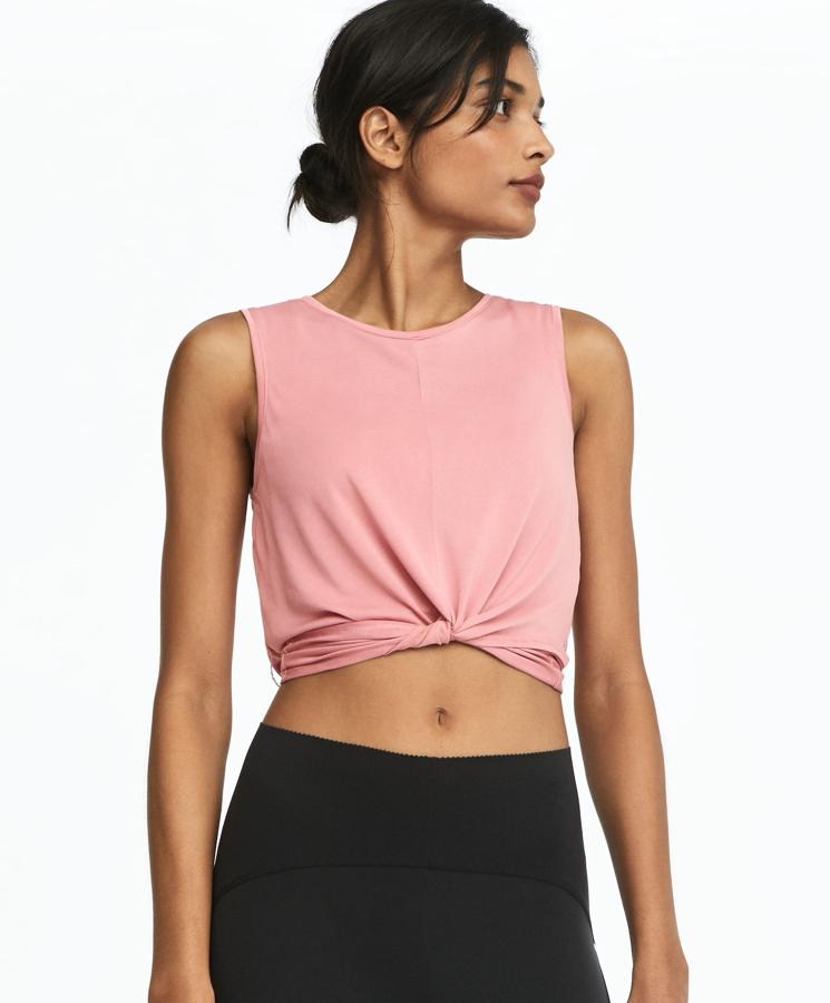 Esta camiseta crop con cuello redondo y manga sisa en color rosa cuenta con detalle de tiras que se cruzan en forma de nudo en la parte delantera. Es de Oysho y tiene un precio de 17,99 euros.
