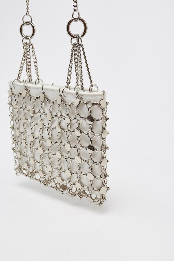 Con asa larga en forma de cadena, este bolso con fondo blanco y red metálica será el protagonista de muchos de tus eventos. Tiene un precio de 27,95 euros.