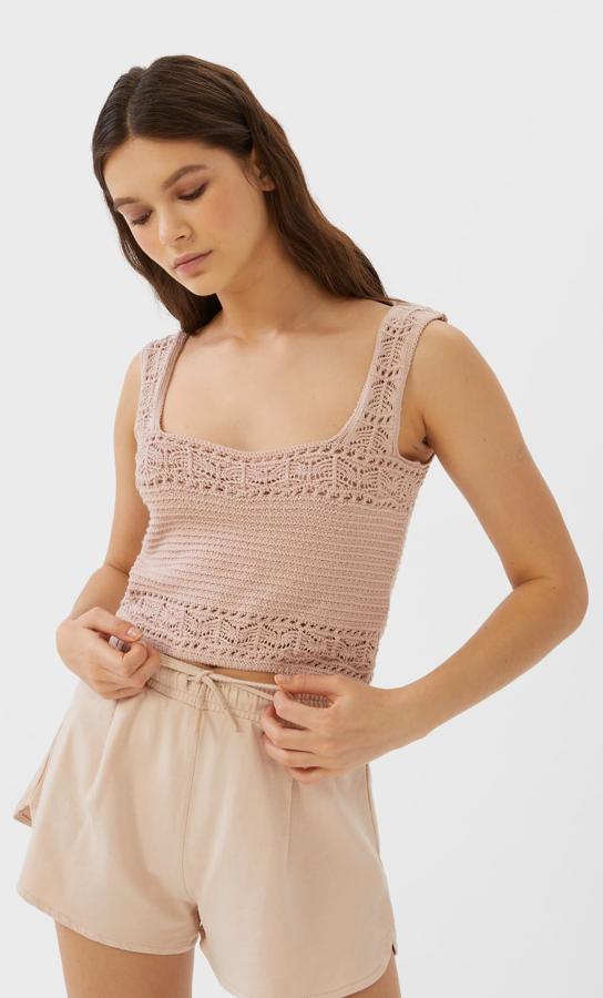 Con bonitas cenefas en la parte superior y el bajo de la prenda, así como en los tirantes anchos, este top cropped crochet de Stradivarius cuesta 12,99 euros y está disponible en color salmón y blanco en las tallas S, M y L.