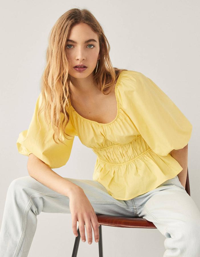 Blusa amarilla de popelín con frunces, de Bershka (15,99 euros).
