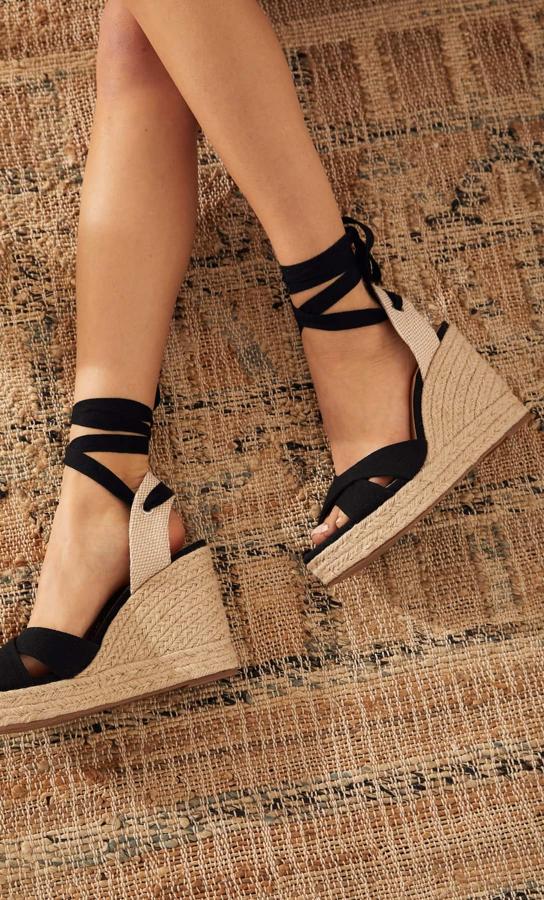 Sandalias con tacón de cuña y tiras negras (29,99 euros).