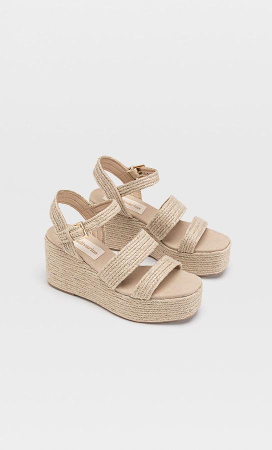 Sandalias de rafia con tacón de cuña y tiras trenzadas (29,99 euros).