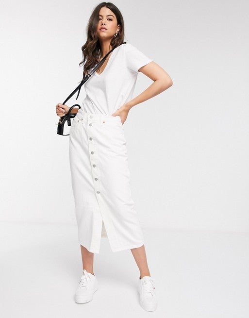 En denim blanco, falda midi con cierre de botones de Levi's. En Asos. (63,75 euros). Un clásico atemporal que es pura tendencia y que sienta de maravilla.