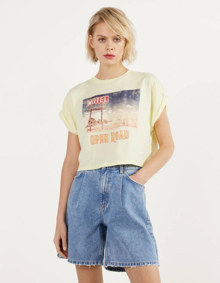 Una de nuestras favoritas es esta camiseta de Bershka en amarillo pastel con estampado fotográfico en el frontal. Con mangas cortas recogidas, tiene un precio de 9,99 euros y está disponible entre las tallas XS y L.