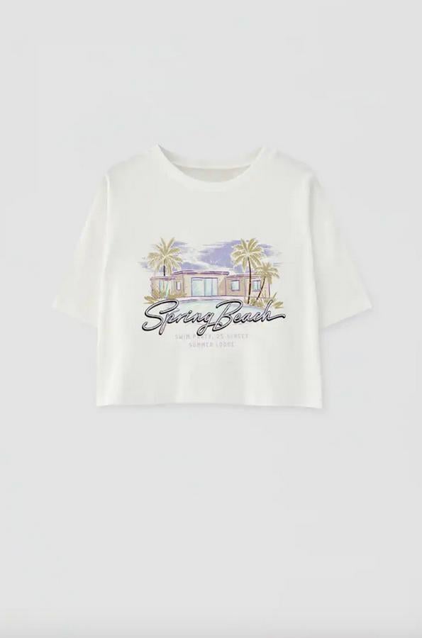 Otra de nuestras propuestas favoritas es esta camiseta cropped de Pull&Bear con una ilustración en contraste que nos transporta directamente a unas buenas vacaciones. Tiene un precio de 9,99 euros y está disponible entre las tallas XS y XL.