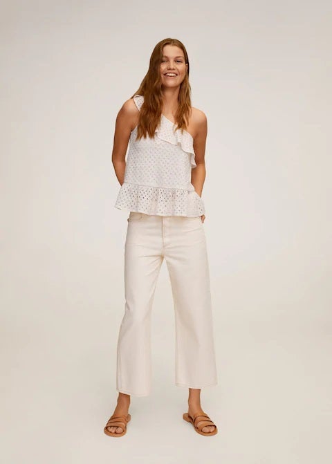 Top blanco asimétrico con volantes y tejido calado de Mango. (19,99 euros).