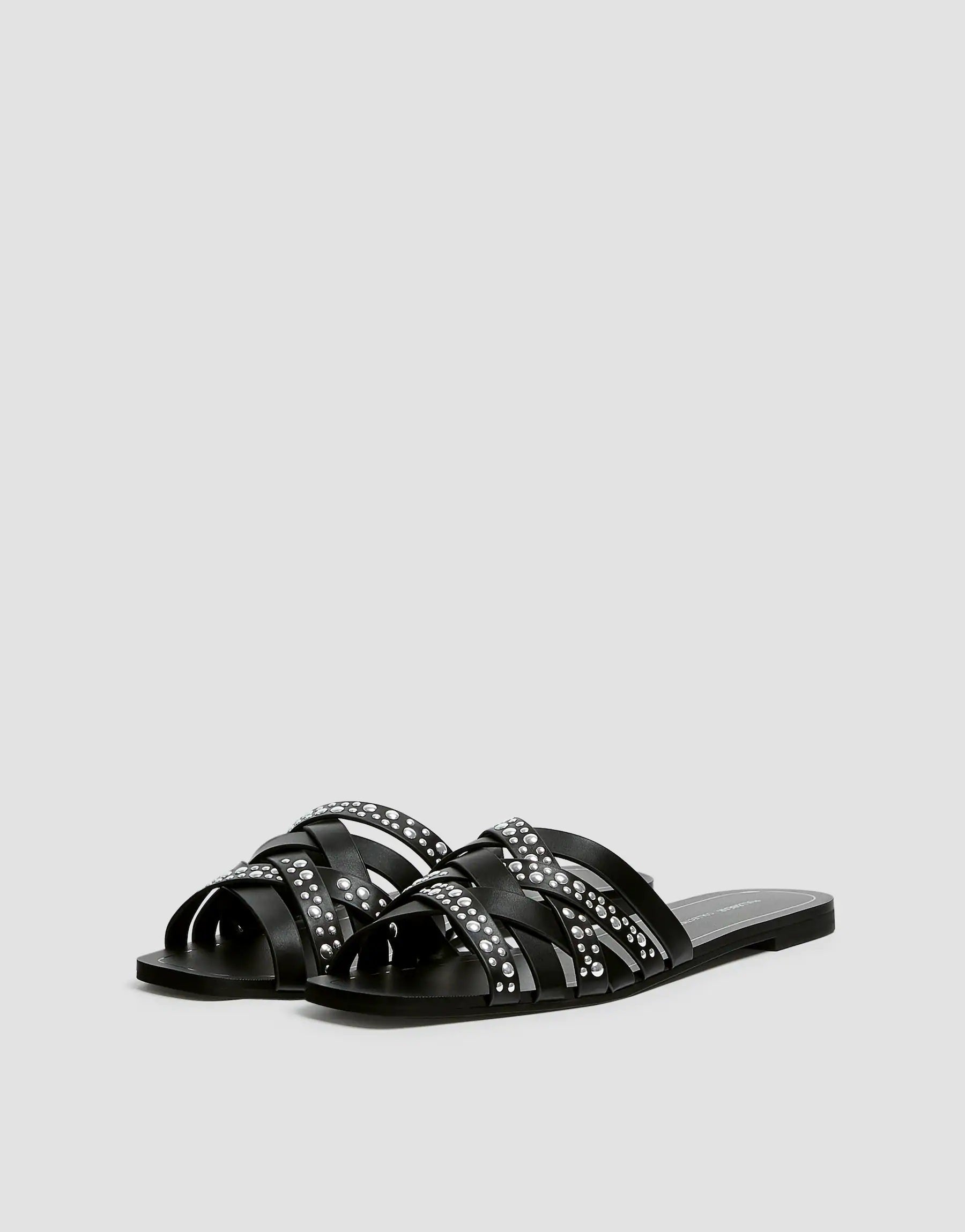 Dale un toque grunge a tu look con estas sandalias planas de tachuelas de Pull&Bear. (25,99 euros).